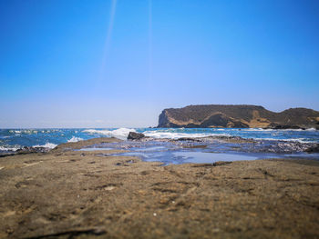 Scenic view of beach against clear blue sky