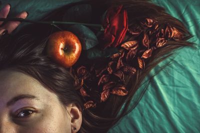 Cropped portrait of woman with apple and rose