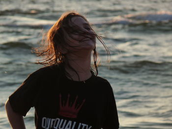 Midsection of woman standing against sea