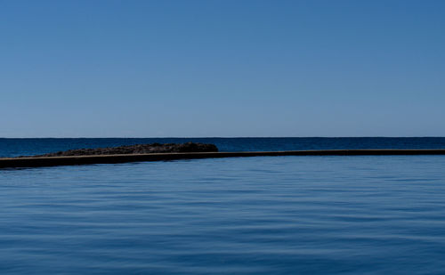 Scenic view of sea against clear blue sky