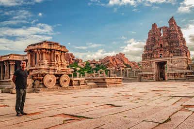 Man standing in temple against cloudy sky