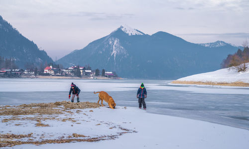 People walking on snowcapped mountain against sky