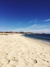 Scenic view of beach against blue sky