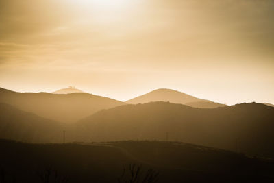 Scenic view of mountains against cloudy sky