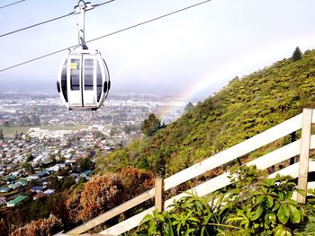 Overhead cable car by mountain above cityscape
