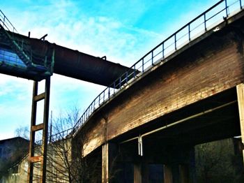 Low angle view of bridge against cloudy sky