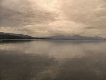 Scenic view of lake against cloudy sky