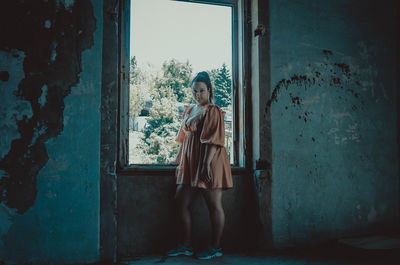 Man standing by window of old building