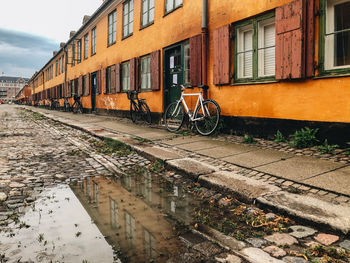 Bicycle parked by building in canal