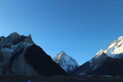 Scenic view of snowcapped mountains against clear blue sky