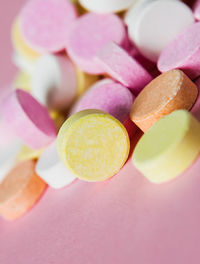 Close-up of multi colored candies over pink background