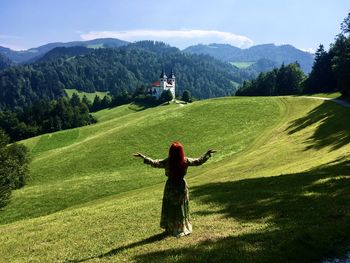 Rear view of a woman on the field in front of the beauty of the creation