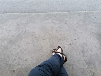 Low section of person standing on concrete floor