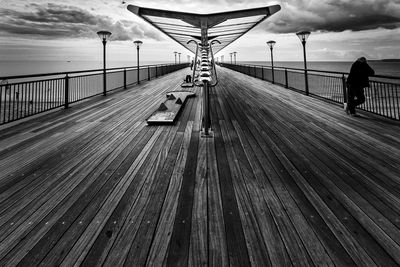 People on bridge against sky