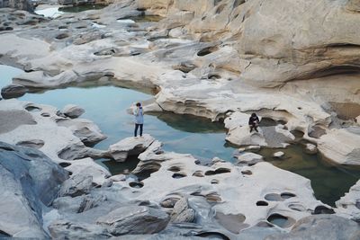 High angle view of friends photographing on rock formations
