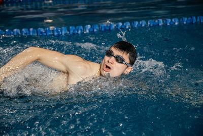 Portrait of shirtless man swimming in pool