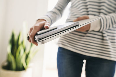 Woman holding portable devices in different sizes