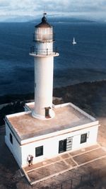 High angle view of lighthouse by sea against sky