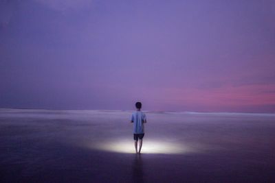 Rear view of man walking on beach