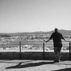 Rear view of woman standing against clear sky