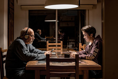 Side view of couple sitting on table