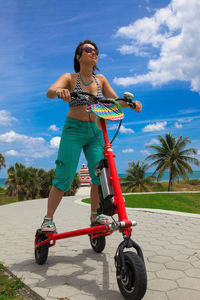 Woman riding motorcycle against sky