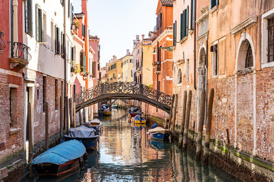 Boats in canal amidst buildings in city