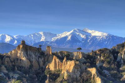 Scenic view of snowcapped mountains against blue sky