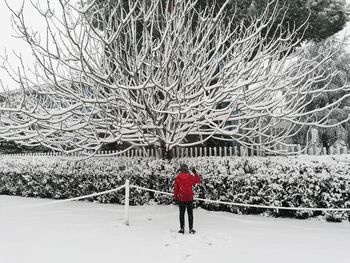 Rear view of man standing on snow covered field