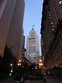 Low angle view of skyscrapers lit up against sky