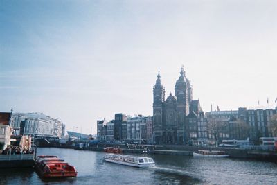 Boats in river with buildings in background