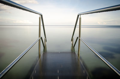 Close-up of steps by sea against sky