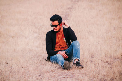 Young man sitting on field