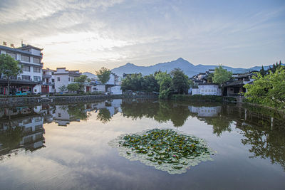 Scenic view of lake by buildings against sky