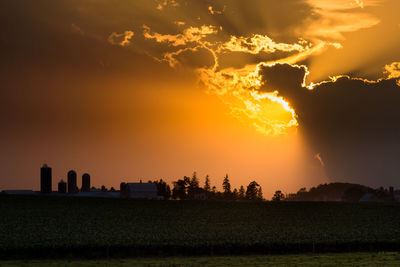 Scenic view of silhouette field against sky during sunset