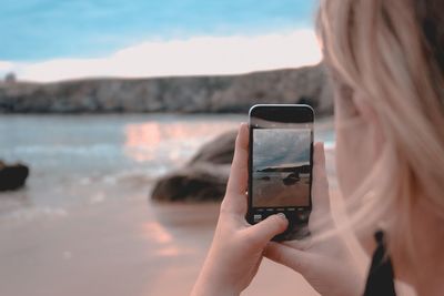 Midsection of woman photographing with mobile phone