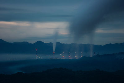 Smoke emitting from chimney against sky