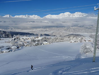 Aerial view of people skiing on snow covered landscape against sky