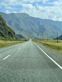 Empty road along landscape and mountains against sky