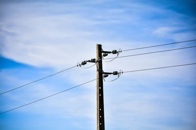 Low angle view of power lines against sky