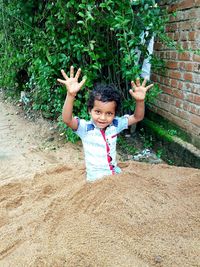 Portrait of innocent boy sitting on sand