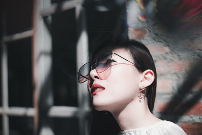 Close-up of beautiful woman wearing sunglasses while looking away