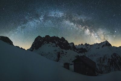 Snow covered landscape against starry sky