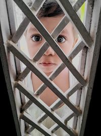 Child watching me through steel gate 