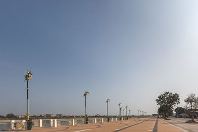 Street by road against clear blue sky