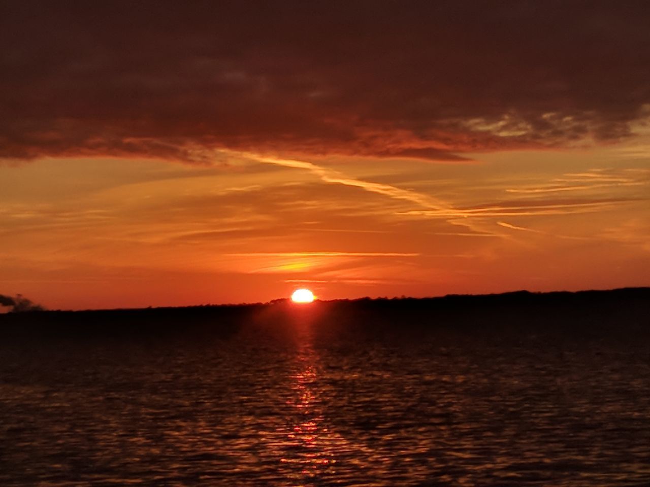 SILHOUETTE OF SEA AT SUNSET