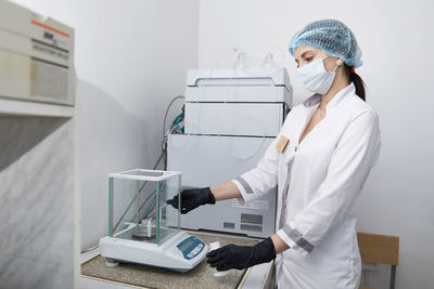 Rear view of woman working on white wall