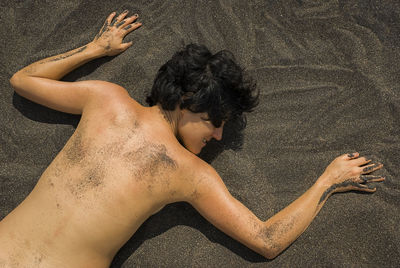 High angle view of man lying on sand
