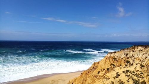 Scenic view of beach against blue sky