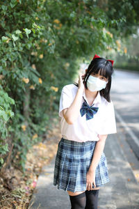Young woman wearing mask standing outdoors